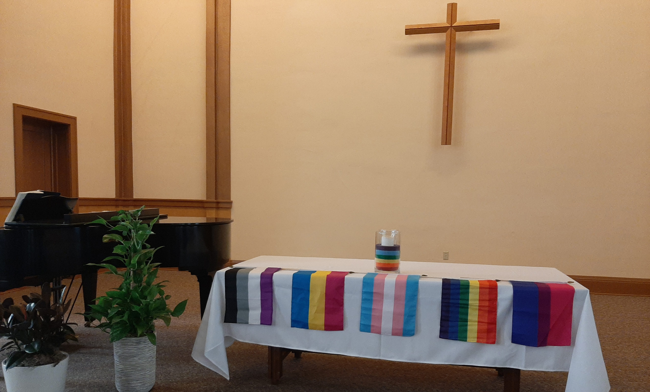 Various pride flags are displayed in the sanctuary of Faith Mennonite Church.